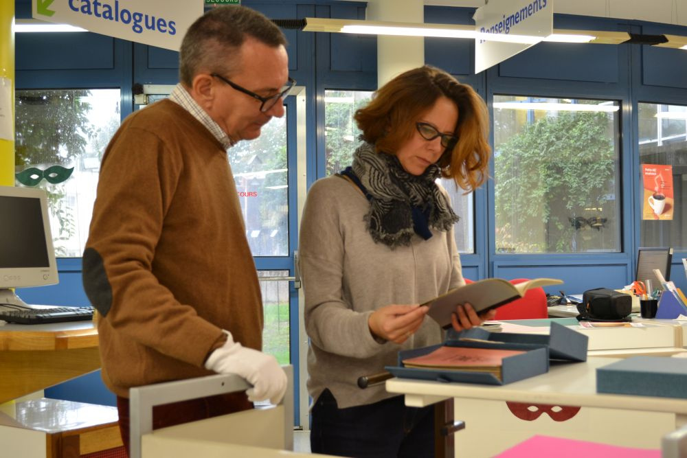 Photographie. Jérôme Leroy et Anne Autissier consultant le manuscrit de Roger Vailland conservé à la Médiathèque de Bourg-en-Bresse.<br>
