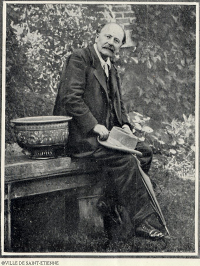 Jules Massenet assis dehors tenant son chapeau à la main.<br>